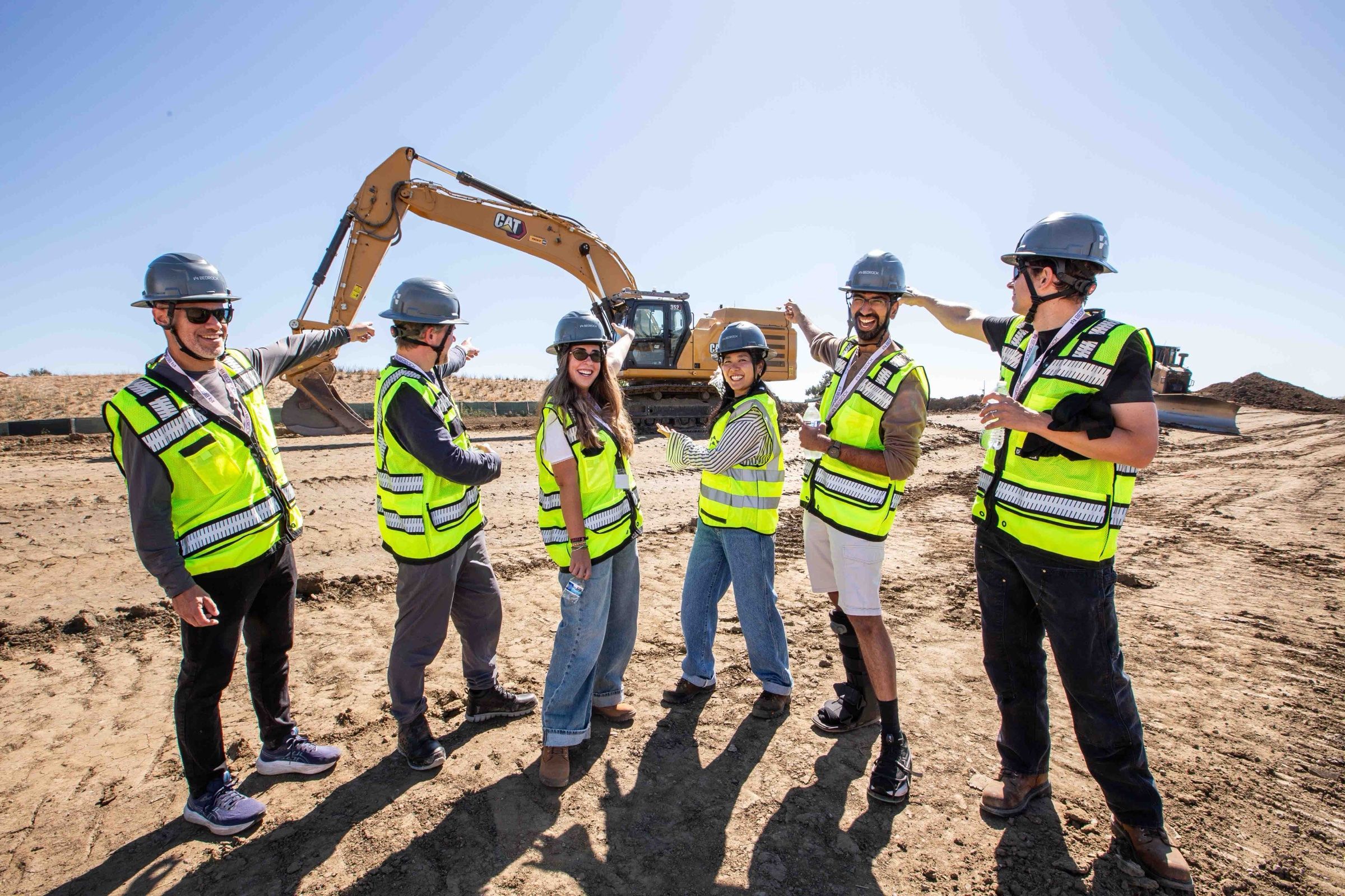 Bedrock team members on a job site in front of an excavator