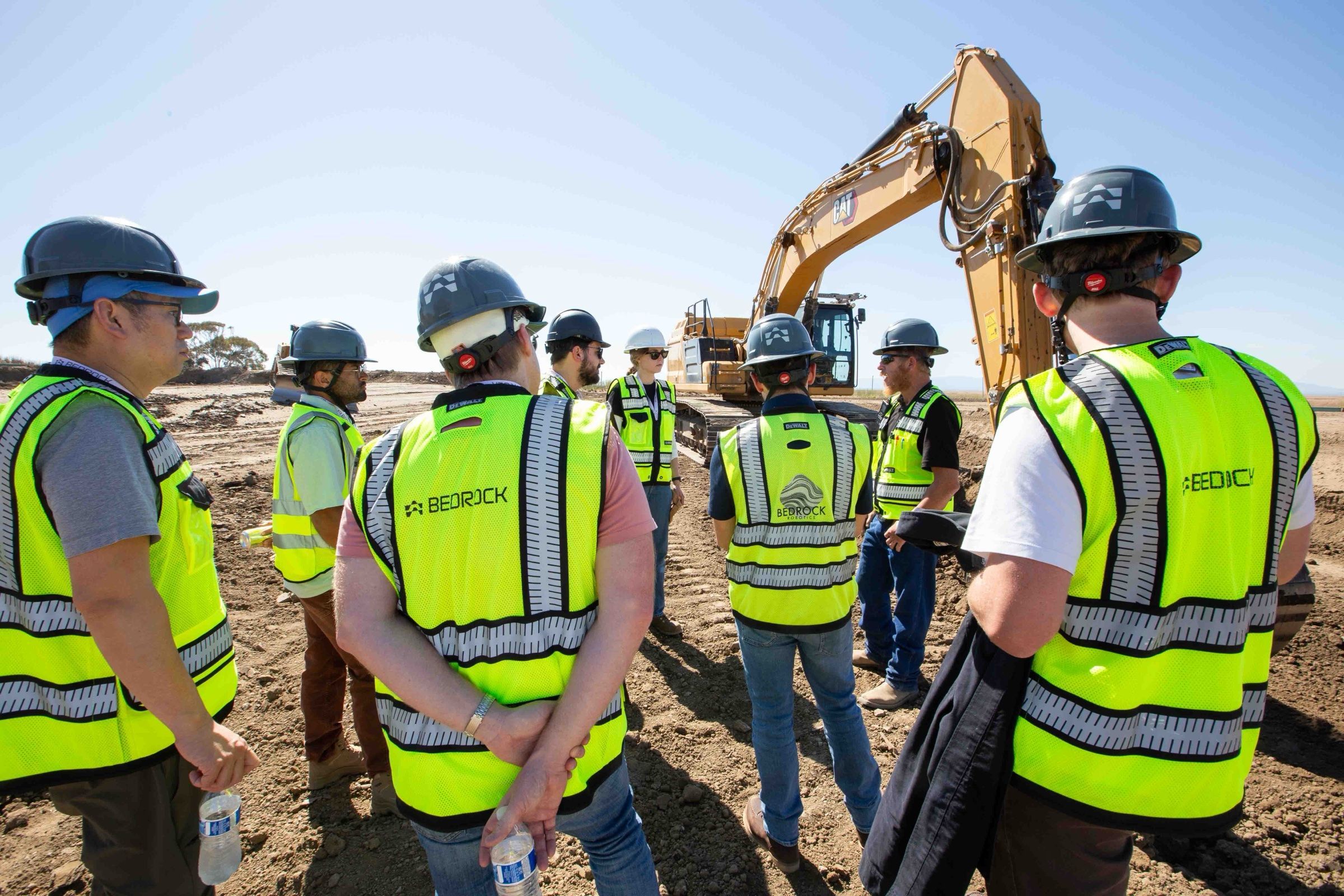 Bedrock team members in hard hats gathered on a job site